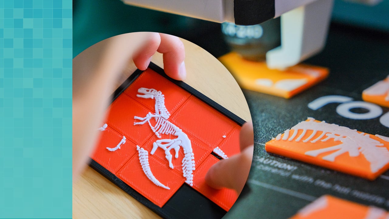  Inset image of a hand playing with a dinosaur three by three puzzle. The image overlaps a close up of the Robo E4 3D printer print plate with 3D printed dinosaur puzzle pieces.